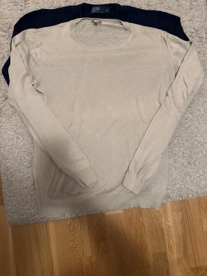 Beige stickad tröja från Uniqlo - Snygg beige stickad tröja från Uniqlo i storlek M. Tröjan har rund halsringning och långa ärmar med ribbade muddar. Perfekt för dig som gillar stilrena och enkla plagg i mjukt material.