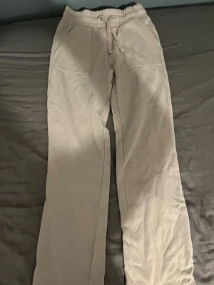 Beige mjukisbyxor med snörning - Snygga beige mjukisbyxor med elastisk midja och snörning framtill. Byxorna har raka ben, två stora fickor fram och två bak. Perfekta för chill dagar och har en loose passform som ger skön vibe. Ordinarie pris( 200kr)aldrig använt plagget 