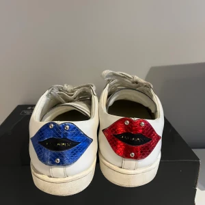 Saint Laurent lip  - Säljer mina saint Laurent lips sneakers. Skorna är i grymt skick och är i princip som nya. Det är storlek 41 men jag skulle säga att det sitter lite större så även om man har 41,5. Man får bara skorna. Skorna är självklar helt äkta. Nypris 7000kr vårt pris 1800!🤝🤩 Bara att skriva vid minsta lilla fundering:)             //ds resell