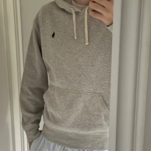 Grå hoodie från Polo Ralph Lauren - Snygg grå hoodie från Polo Ralph Lauren med klassisk broderad logga på bröstet. Tröjan är nästan helt ny och har tvättats max 3 gånger.