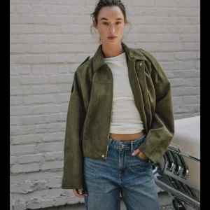 Zara jacka grön - Säljer en oversized olivgrön bomberjacka i mjuk mocka med dragkedja framtill och bred krage. Jackan har långa ärmar och en loose fit som ger en chill vibe. Perfekt att slänga över en t-shirt eller hoodie för en cool look. Använt EN GÅNG så praktiskt talat by.snabbt köp 