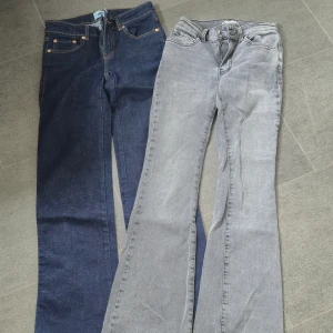 Två par bootcut jeans, blå & grå - Säljer två par bootcut jeans, ett par i mörkblå denim storlek XXS och ett par i ljusgrå tvätt och Jeans i storlek 32. Båda har klassisk femficksdesign och är tillverkade i mjukt jeanstyg. Perfekta för dig som gillar retrovibbar och snygg passform.