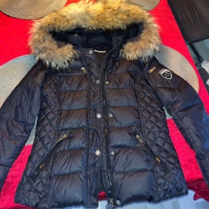 Svart dunjacka från Rock & Blue - Säljer en snygg svart dunjacka från Rockandblue i storlek 38/Medium passar även S. Jackan har en mysig pälsfodrad huva och flera praktiska dragkedjefickor och även inneficka! . Perfekt för kalla vinterdagar! Mycket fint skick! Nypris 2500 isch! 