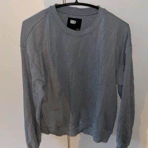 Grå sweatshirt i bomull - Enkel och stilren ljusblå sweatshirt från lager 157 Tröjan har rund halsringning, långa ärmar och ribbade muddar vid ärmslut och nederkant. Perfekt för en chill och avslappnad look.