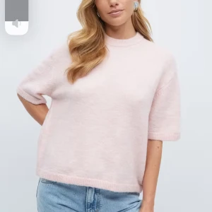 Ljusrosa stickad tröja från Gina Tricot - Supermjuk ljusrosa stickad tröja från Gina Tricot med korta ärmar och rund halsringning. Tröjan har en loose passform och ribbade kanter vid ärmslut och nederkant. Perfekt för lager-på-lager och chill vibes.