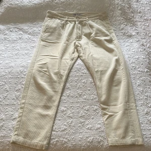 Beiga manchesterbyxor från Zara - Säljer ett par beiga manchesterbyxor från Zara med klassisk rak passform. Byxorna har bälteshällor, sidofickor och två bakfickor med knapp. Materialet är mjukt och ger en chill vibe, perfekt för dig som gillar stilrena och bekväma plagg.