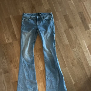 True Religion Joey Low Rise Flare Jeans - Ett par blåa true religion low waist jeans som är använda max 3ggr