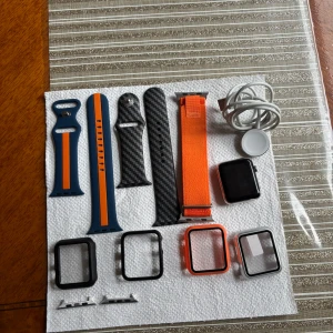 Apple Watch 42mm - Med tillbehör - Prisförslag - Apple Watch 42mm säljes.  Kommer med 3 armband, 4 skydd, laddare ochtvå tillbehör till om man vill lägga ett annat armband. Klockan är i bra skick och den har använts ett fåtal gånger. Men allt fungerar som det ska. Det finns redan ett skärmskydd på utan skador. Klockan har nollställts som ni ser på bilden. Modell: 1st gen, 2015 vecka 27  Kontakta vid eventuella frågor.