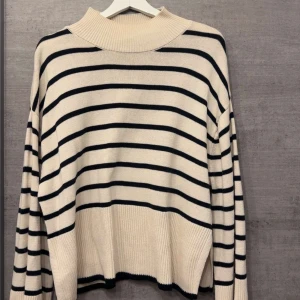 Randig stickad tröja från Gina Tricot - Säljer en beige och svart randig stickad tröja från Gina Tricot. Bra till vintern 🩷
