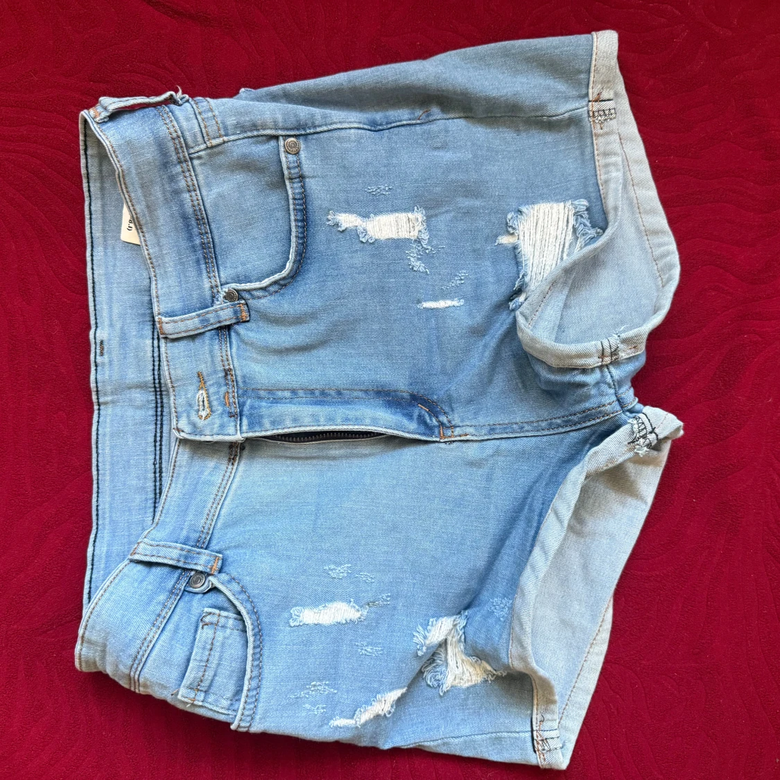 Ljusblå slitna jeansshorts