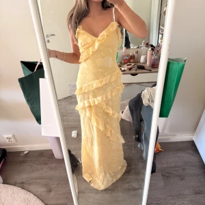 Ljusgul långklänning med volanger - Jättefin klänning. Passar perfekt till olika tillfällen💛💛Använd endast 1 gång så är i bra skick med! 