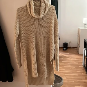 Beige stickad polotröja Noisy May - Mysig beige stickad polotröja från Noisy May. Lång modell med slitsar i sidorna, grovstickad struktur och ribbade muddar. Perfekt för lager-på-lager och chill höst- och vinterstil.