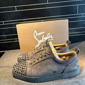 Cristian Louboutin  - Säljer dessa Louboutin skor i storlek 43 som är grå/bruna i färgen. Bra skick förutom en fläck på mockan allt og följer med 