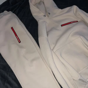 Beige prada dress  - Beige dress med hoodie och byxor från prada. Riktigt bekväm och snygg dress, jättebra kvalité. Skulle säga att den är nyskick ut över en liten fläck på vänster arm som knappt syns (bild kan jag fixa)  Storlek XL på hoodie & byxor! Priset är diskuterbart. Hör av er vid frågor!