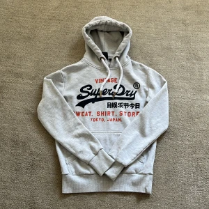 Superdry Hoodie - Tja! Säljer nu denna feta Superdry Hoodien! Den är fodrad så den är perfekt nu till dessa kyligare dagar!❄️ Nypris: 1499 kr❌‼️Vårt pris: 499 kr✅ Skriv vid minsta fundering eller fråga, och pris kan diskuteras!🤝