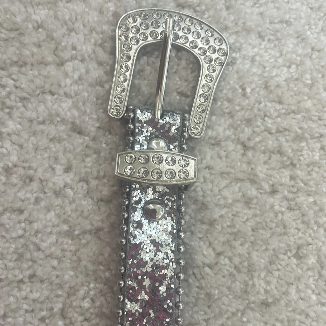 Glittrigt silverbälte med nitar