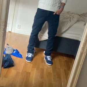 Mörkblå jeans från Dressmann 30/32 - Snygga mörkblå jeans från Dressmann i klassisk rak modell. Jeansen har fem fickor, normal passform och är tillverkade i mjukt bomullsjeans-tyg. Perfekta för dig som gillar stilrena och enkla jeans med en tidlös look.