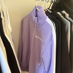  Palm Angels kofta Lila - Säljer en lila ziptröja från Palm Angels. Perfekt för en sportig och trendig look PRIS KAN DISKUTERAS .