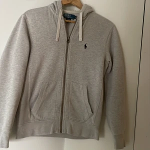 Ljusgrå hoodie från Polo Ralph Lauren - Skitsnygg ljusgrå hoodie från Polo Ralph Lauren med dragkedja. Pris ej hugget i sten! Hör av er vid fundering!❤️