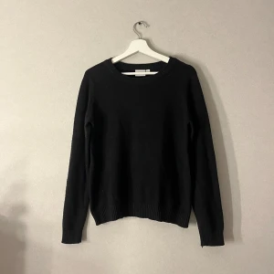 Svart stickad tröja från Vila - En klassisk svart stickad tröja från Vila med rund halsringning och ribbade muddar vid ärmslut och nederkant. Perfekt basic-plagg med lång ärm och enkel design som funkar till allt. Superenkel att styla och ett måste i garderoben. Storlek M men sitter ganska tajt så de beror på om man vill ha den oversize elr vanlig. Putte lite nioårig inget som märks. Pris kan diskuteras🤗