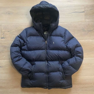 Polo Ralph lauren jacka - Säljer denna riktigt snygga Ralph lauren vinterjackan i mycket bra skick! Storlek xl 18-20 barnstolek vilket motsvarar xs/s, polaren på bilderna är 185 cm och väger 65 kg, tjock och varm jacka som passar perfekt nu till kallare dagar framöver! Hör gärna av dig vid frågor!