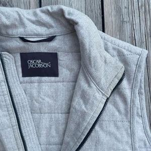 Oscar jacobson väst - Otroligt stilren och snygg Oscar jacobson väst. Mest hängt i garderoben då den tyvärr  inte är min storlek. Kvaliteten är otroligt bra både på västen men även dragkedjan. Nypris 2300kr, st 48-M. 