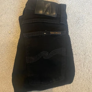 Svarta nudie jeans w24 - Säljer ett par nudie jeans i strl w24 L30. Passformen är tight terry. Mitt pris: 400 kr , nytt pris 1400 kr. Är som helt nya har inga defekter, säljs pågrund av det är lite små. Jeansen passar folk men ungefär 155-165. Skriv frågor om funderingar. 