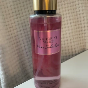 Victoria's Secret Pure Seduction mist - En snygg rosa parfymmist från Victoria's Secret, Pure Seduction. Flaskan är genomskinlig med guldigt lock och rymmer 250 ml. Doften är fruktig och söt, perfekt för dig som gillar en fräsch och ungdomlig vibe.
