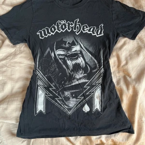 Svart Motörhead t-shirt med tryck - Cool svart t-shirt med stort Motörhead-tryck framtill och klassisk rund hals. T-shirten är kortärmad och och har en loose passform. 