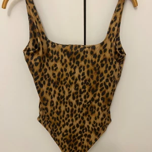 Leopardmönstrad body från H&M - Supersnygg och trendig body i leopardmönster. Figurnära passform och lätt att styla både till vardag och fest. Aldrig använd och är i bra skick. 