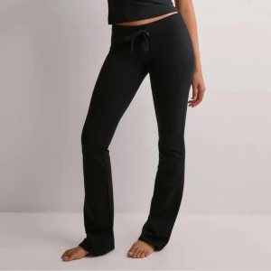 Nelly cozy chill pants - Svarta mjukisbyxor med bootcut-snitt och snörning i midjan. Byxorna har en bekväm passform och är perfekta för en avslappnad stil. Tillverkade i mjukt material som känns skönt mot huden.