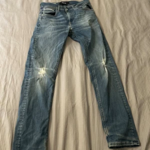 Blå Replay jeans med slitningar - Säljer ett par blå replay hyperflex jeans med naturliga slitningar. Nypriset är ca 1200kr. Skicket är som nytt bara att lappen där bak sitter lite löst. Hör av er om frågor eller bud 