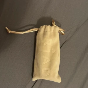 RIAD Absolutes parfymflaska med påse - RIAD Absolutes parfym i smidig flaska med lyxig guldapplikation och tillhörande tygpåse. Perfekt att ta med i väskan för en fräsch känsla när som helst. Volym och ingredienser framgår ej heller på bilderna. Den är helt full 