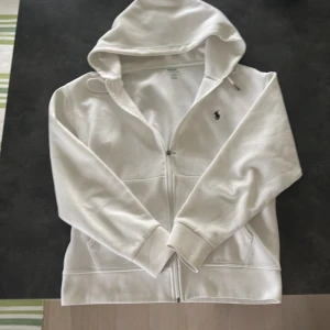 Vit Zip hoodie från Ralph Lauren - Otroligt snygg och populär zip hoodie från Ralph lauren i vitt. Jättefint skick och passar som S och M. Ställ fråga vid minsta fundering ✅