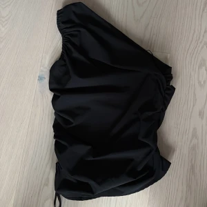 Svart one shoulder topp från Zara - Säljer en svart one shoulder topp från Zara i storlek S. Toppen har en snygg scrunch på båda sidorna.🥰 använd fåtal gånger. Säljer pga att den inte används🥰