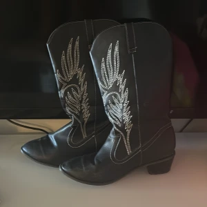 Svarta cowboy boots med mönster - Säljer mina snygga cowboy boots som endast är använda 4 gånger ish! Så väldigt bra skick! Kommer inte ihåg var det är köpta.