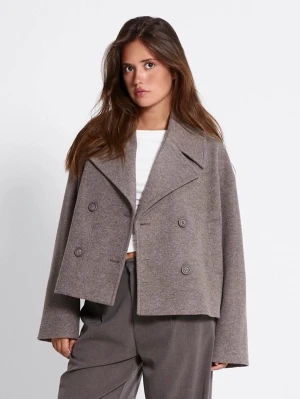 Beige dubbelknäppt rock med bred krage - Säljer en beige rock med bred krage och dubbelknäppning. Jackan har en loose passform och långa ärmar, perfekt för dig som gillar en chill och stilren look. Passar bra över en hoodie och har en klassisk design med stora knappar framtill.