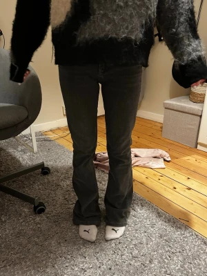 Gråa bootcut jeans från gina - Säljer ett par gråa jeans från gina med bootcut-snitt. Byxorna har klassisk femficksdesign och är tillverkade i ett mjukt jeansmaterial. Passformen är normal och midjan är midwaist. Perfekta för dig som gillar retrovibbar och vill ha en snygg siluett. Storlek 158/164