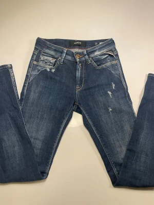Replay jeans - Säljer ett par snygga Replay jeans med slitningar och blekningar på modellen heter new luz. storlek 25