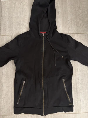 Hugo Boss Hoddie - Svart Hoddie från Hugo Boss, Storlek S, bra skick med små flaws på ett ställe vid bröstet. Inget man märker av eller ser, om man inte tittar extremt noga.