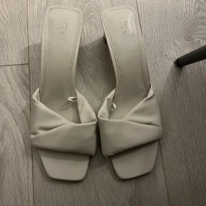 Beige sandaler med klack  - Snygga beige sandaler från H&M med låg klack och fyrkantig tå. De har en snygg omlott-detalj över foten och är tillverkade i syntetmaterial. Använda fåtal gånger🤍 