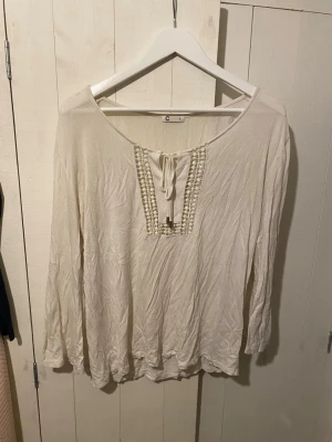 Snygg blus  - Skit snygg blus med fina detaljer framtill. Passar perfekt till sommaren för en fräsch look. Tröjan har trekvartsärmar och en lös design