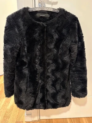Svart pälsjacka från Vero Moda M defekt  - En välanvänd fuskpälsjacka från Vero moda. Försluts med knappar. Har två fickor.   Det enda anmärkningsbara är att sömmen under ena ärmen släppte i jackans insida, och det har jag sytt för hand. Det är inget man märker av när man har på sig jackan. Har man en symaskin eller är mer händig än jag, kan man åtgärda det finare dock :)   Likaså hade ena fickans söm släppt och det har jag också sytt för hand, det känns ojämnt om man har handen i fickan där jag har sytt för hand. Inget som syns utåt set