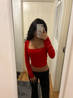 Röd croppad långärmad topp - Säljer en röd croppad topp med lång ärm och fyrkantig urringning. 