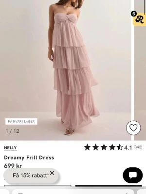 Ljusrosa långklänning från Nelly - Drömmig ljusrosa långklänning med flera lager volanger och axelbandslös, helt oanvänd fortfarande kvar i påsen