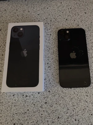 Apple iPhone 13  128 GB Midnight - Säljer nu min iPhone 13 (128 GB) i färgen Midnight. Telefonen fungerar perfekt och precis som den ska.   Köptes sommaren 2024 från Elgiganten och säljs då jag har fått en ny telefon i present. Batterihälsan är på 90%. Orginalförpackning och ny laddningskabel följer med.   Sprickor finns på baksidan, men påverkar inte funktion eller användningen på något sätt.