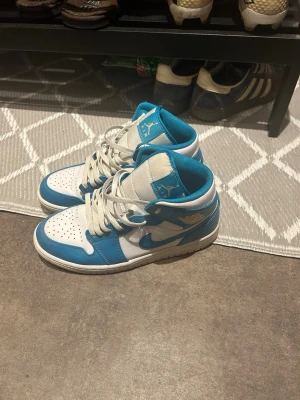 Nike Air Jordan 1 blå och vita - Säljer ett par Nike Air Jordan 1 i blått och vitt.                Storlek 42 säljer pågrunda av att jag aldrig använder dom längre använda ungefär en halv sommar 