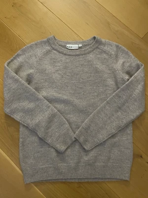 Stickad tröja  - Mysig grå stickad tröja från R.M.D med rund halsringning och ribbade muddar vid ärmslut och nederkant. Perfekt för lager på lager under kyliga dagar. Enkel och stilren design som passar till det mesta.
