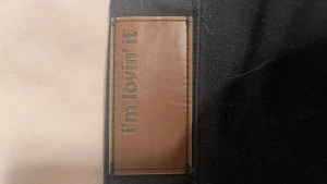 Donken byxor  - Säljer ett par svarta cargopants med cool brun patch där det står 'i'm lovin' it'. Byxorna har stora fickor på sidorna och är gjorda i ett slitstarkt bomullstyg. Perfekta för dig som gillar streetwear och vill ha något bekvämt men ändå snyggt.