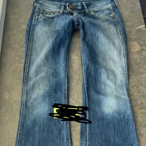 Blå bootcut jeans  - Snygga blå bootcut jeans  med  ljusare partier framtill och baktill. Klassisk femficksmodell, låg midja och detaljerade sömmar. Perfekta för dig som gillar en avslappnad och trendig look. Säljer då de inte kommer till användning💓Midjemått tvärsöver är 40 cm, midjehöjd 18 cm och innerbenslängd 83 cm❤️ Kan tänka mig att sänka priset💓